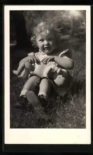Foto-AK Kleines Mädchen mit nackter Puppe im Sonnenschein