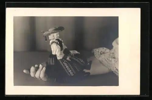 AK Puppe in Tracht sitzt auf der Hand