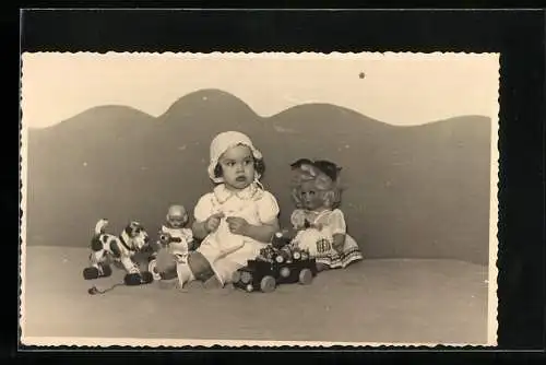 Foto-AK Kleines Kind mit Puppen und Spieltieren