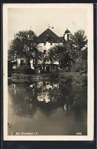 AK Kitzbühel i. T., Weisses Gebäude mit Zwiebeltürmen, vom Wasser gesehen