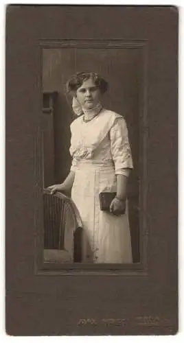 Fotografie Max Horst, Pirna a. E., Garten-Str. 31, Junge Frau im weissen Kleid mit Rollkragen mit einem Buch