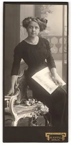 Fotografie M. Appel, Berlin, Neue Königstr. 1, Junge Frau mit eleganter Frisur und einer Zeitung in der Hand