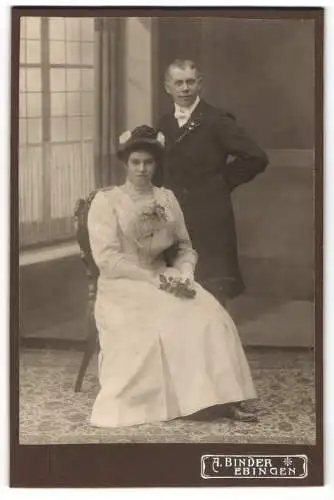 Fotografie A. Binder, Ebingen, Junge Frau im eleganten Kleid mit einer Rose vor ihrem Ehemann