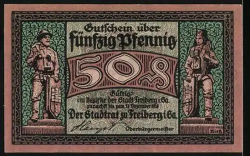 Notgeld Freiberg, 50 Pfennig, Mann schiebt Lore, zwei Figuren mit Schilden