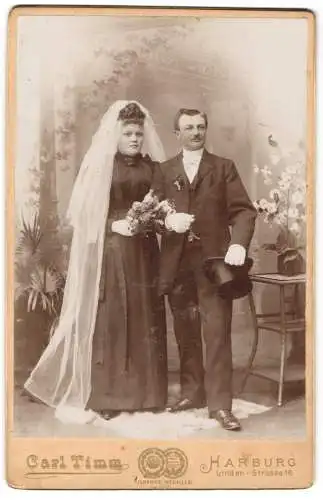 Fotografie Carl Timm, Harburg / Elbe, Hochzeitspaar im schwarzen Brautkleid mit Schleier und Anzug mit Zylinder