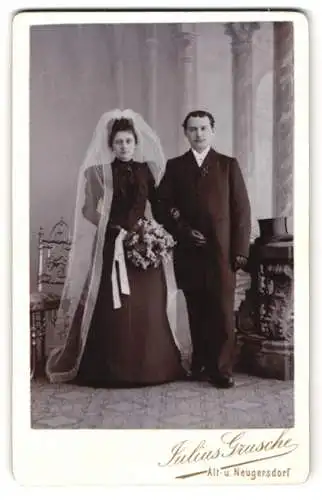 Fotografie Julius Grusche, Neugersdorf, junges Ehepaar im schwarzen Brautkleid mit Schleier und Anzug nebst Zylinder
