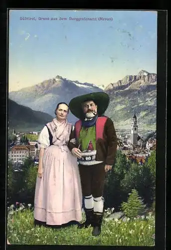 AK Meran, Paar in Südtiroler Tracht vor Orts- u. Bergpanorama