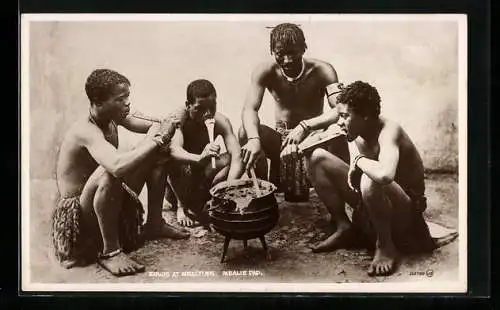 AK Zulus at Mealtime, afrikanische junge Männer essen aus einem Topf heraus