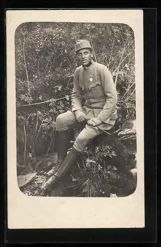 Foto-AK Junger Soldat in Uniform an einem Bachlauf, mit einem Orden