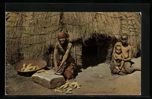 AK Native Woman grinding mealis, afrikanische Frauen vor der Hütte mit Mais