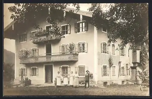 Foto-AK Unterwössen, Familie vor einem grossen Wohnhaus