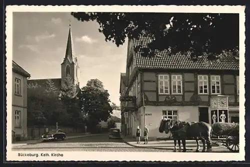 AK Bückeburg, Strassenpartie mit kath. Kirche und Pferdefuhrwerk mit Eichenstamm