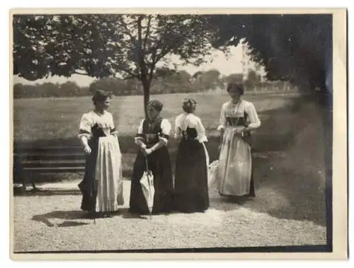 Fotografie unbekannter Fotograf und Ort, vier Damen in Schweizer Tracht mit Sonnenschirm