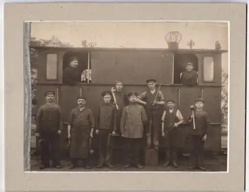 Fotografie unbekannter Fotograf und Ort, Eisenbahner / Gleisbauer vor einer Kleinbahn mit Werkzeug in der Hand