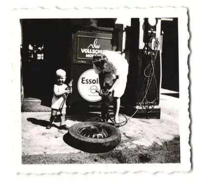 Fotografie unbekannter Fotograf und Ort, Vater mit seinen Sohn an einer Esso Tankstelle beim Reifen aufpumpen, 1942