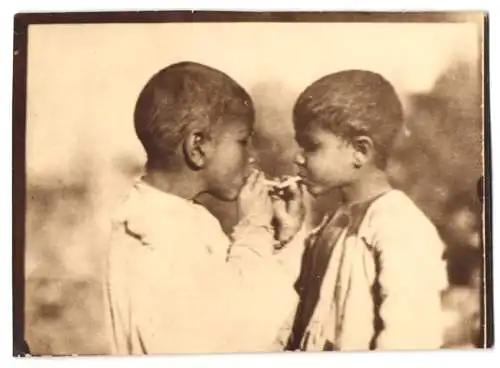 Fotografie unbekannter Fotograf und Ort, zwei kleine Strassenkinder rauchen Zigarette miteinander