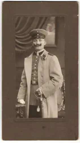 Fotografie K. Bauer, Karlsruhe, Uffz. in Uniform mit Mantel und Säbel, Mustasch