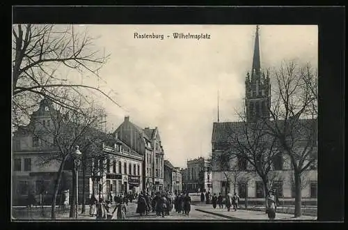 AK Rastenburg, Geschäfte am Wilhelmsplatz, Kirche