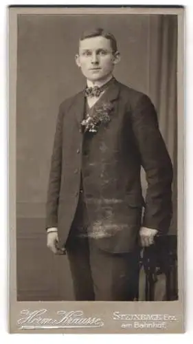 Fotografie Heim Krausse, Steinbach Erz., am Bahnhof, Portrait eines jungen Mannes im Anzug mit Blumenanstecker