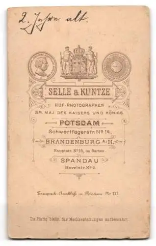 Fotografie Selle & Kuntze, Potsdam, Schwertfegerstrasse 14, Kleines Kind in dunklem Kleid neben Stuhl