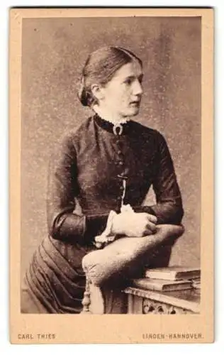 Fotografie Carl Thies, Linden-Hannover, Deisterstrasse, Junge Frau in dunklem Kleid, an Tisch gelehnt