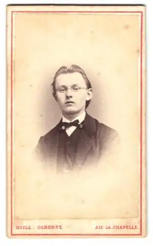 Fotografie Guill. Olbertz, Aix-la-Chapelle, Comphausbadstrasse 29, Portrait eines jungen Mannes in Anzug und Fliege.