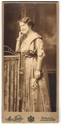 Fotografie Max Fischer, Berlin, Invalidenstrasse 164, Frau in elegantem Kleid mit Blumenstrauss