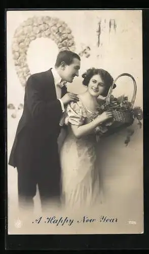 Foto-AK NPG Nr. 1725: Ein junges Paar in Abendkleidung mit einem Korb Glücksklee, Neujahrskarte