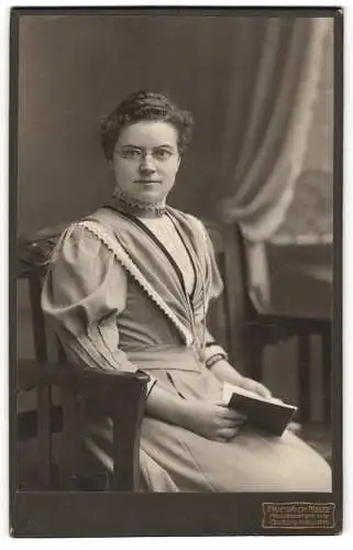 Fotografie Friedrich Meltz, Quedlinburg, Heiligegeiststrasse 11-12, Junge Frau mit Brille und Buch in edlem Kleid