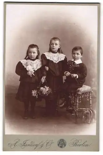 Fotografie A. Jandorf & Co., Berlin, Grosse Frankfurterstr. 113, Drei Kinder mit Blumen und Puppe