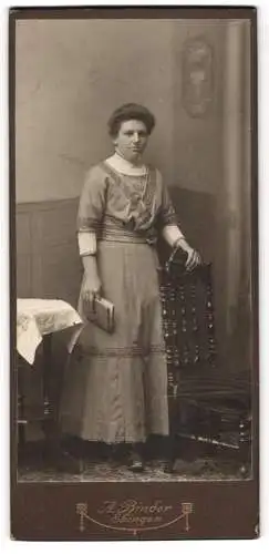 Fotografie A. Binder, Ebingen, Stehend porträtierte Frau mit Buch in der Hand.