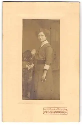 Fotografie Carl Spahn, Olbernhau, Junge Frau in zeitgenössischem Kleid mit Blumenstrauss