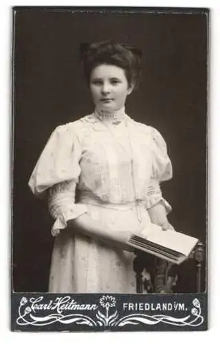 Fotografie Carl Heitmann, Friedland i. M., Junge Frau im weissen Kleid mit Buch