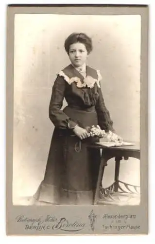 Fotografie Atelier Berolina, Berlin, Alexanderplatz, Junge Frau mit Blumenstrauss am Tisch.