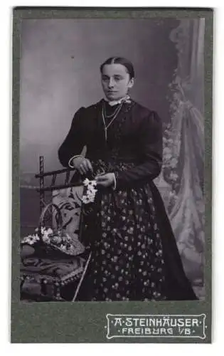 Fotografie A. Steinhäuser, Freiburg i/B., Karthäuserstr. 4, Frau in traditioneller Kleidung mit Blumenkorb