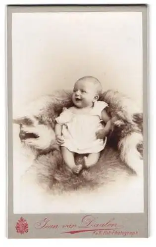 Fotografie Jean van Daalen, Aalen, Bahnhofstrasse, Lächelndes Baby auf weichem Fell