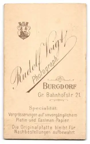 Fotografie Rudolf Voigt, Burgdorf, Gr. Bahnhofstr. 21, Mädchen mit Buch sitzt an einem Tisch mit Blumenvase