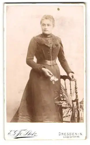 Fotografie E. G. Friedr. Stotz, Dresden, Leipzigerstr. 49, Junge Dame im eleganten Kleid mit Blume