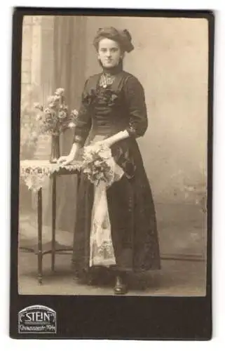 Fotografie Atelier Stein, Berlin, Chausseestr. 70 /71, Junge Frau im dunklen Kleid mit Blumenstrauss