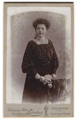 Fotografie Atelier Berolina, Berlin, Alexanderplatz, Junge Frau in gepunkteter Bluse mit Blumenstrauss