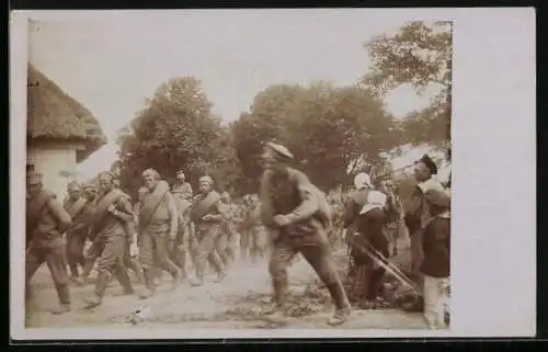 Foto-AK Gefangene Russen auf dem Marsch durch eine Ortschaft