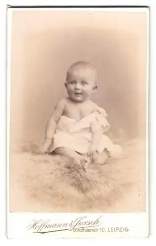 Fotografie Hoffmann & Jursch, Leipzig, Dorotheenstr. 10, lächelndes Baby auf einem flauschigen Teppich