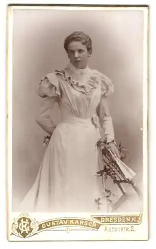 Fotografie Gustav Karsch, Dresden, Antonstr. 2, Junge Frau in elegantem weissen Kleid mit Blumenstrauss