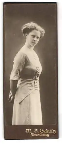 Fotografie M. B. Schultz, Flensburg, Junge Frau in elegantem Kleid mit geflochtenem Haar