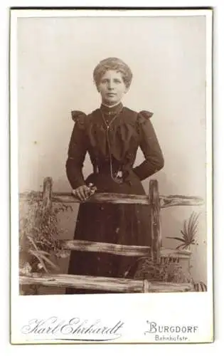 Fotografie Karl Ehrhardt, Burgdorf, Bahnhofstr., Dame in dunklem Kleid hinter rustikalem Holzzaun