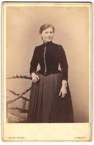 Fotografie Carl Rose, Lübeck, König-Strasse 53, Junge Frau in dunklem Kleid mit Perlenknopfleiste