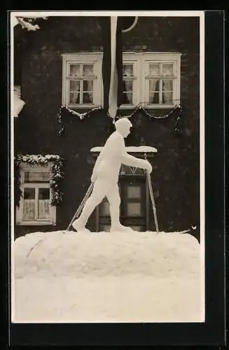 AK Ein Ski-Langläufer vor einem Haus, Schneeplastik