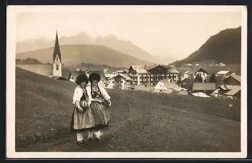 AK Seefeld i. T., Zwei junge Frauen in Tracht vor der Ortschaft