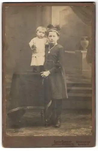 Fotografie Gustav Borchert, Wernigerode, Bahnhofstr. 10, Mädchen stützt Kleinkind auf Tisch stehend