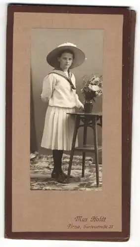 Fotografie Max Holdt, Pirna, Gartenstrasse 31, Mädchen in Matrosenkleid neben Tisch mit Blumenstrauss